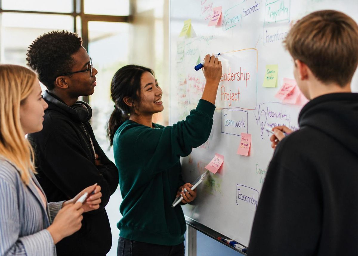 Colleagues collaborating around a whiteboard